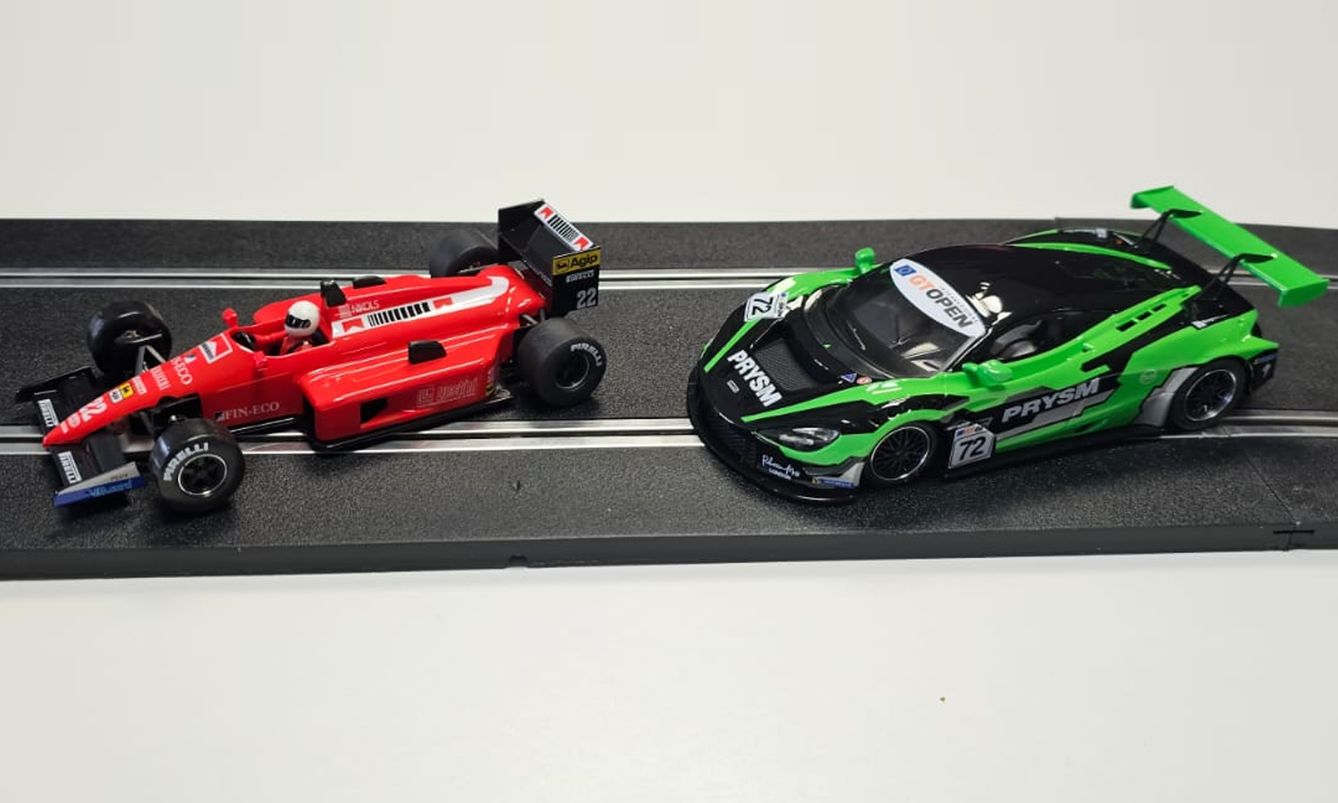 Click To Enlarge. Two NSR slot cars displayed on a piece of slot car race track.