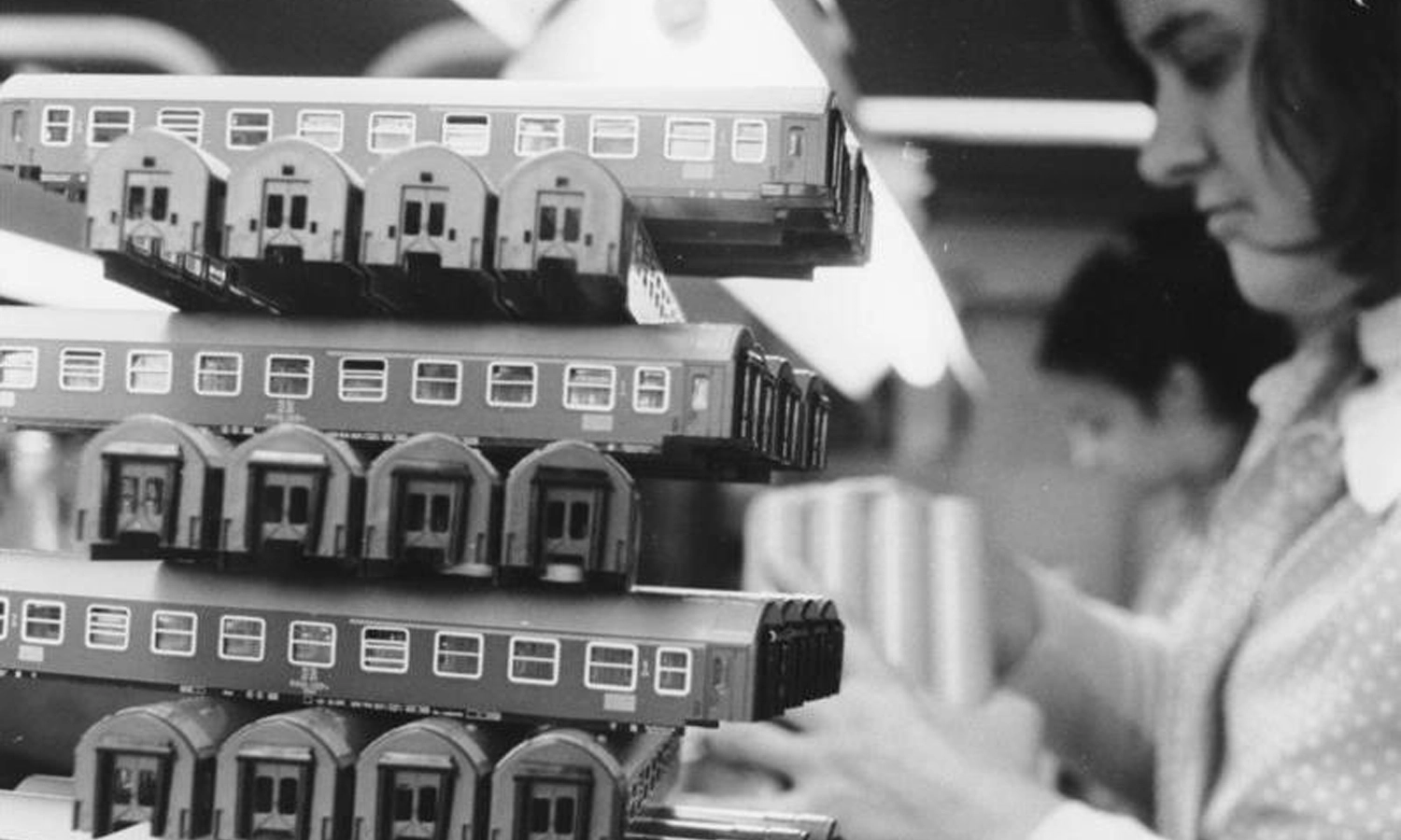 a factory worker assembling model railway coaches